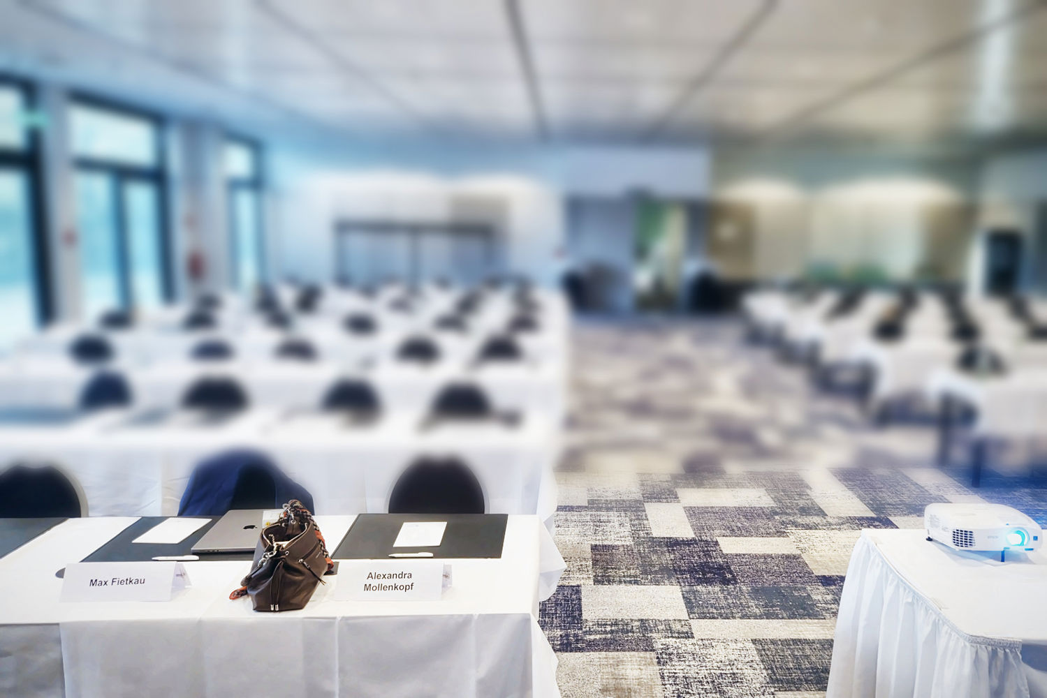 Leerer Tagungssaal im Holiday Inn Berlin City West vor Beginn, vorne Namensschilder von Max Fietkau und Alexandra Mollenkopf